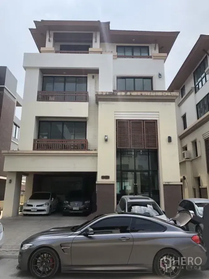 Home Office for rent in Wang Thonglang, Bangkok - Four-storey home office exterior with tall glass entry, balconies and covered parking for several cars.