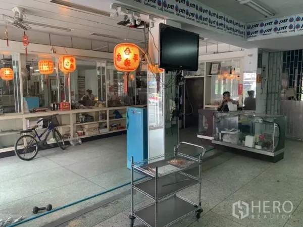 Shophouse for rent in Khlong Toei, Bangkok - Retail interior with cashier counter, hanging lanterns, TV mount and open floor ready for fit-out.