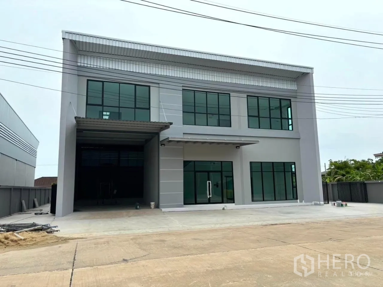 工厂 出租或出售在Bang Bo, Samut Prakan - 两层现代工厂外立面，玻璃办公区与宽阔车道，位于邦博·北榄府。