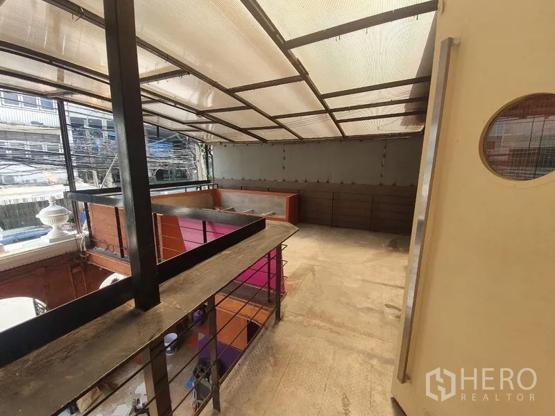 店屋 出租在Khlong Toei, Bangkok - 带顶棚的上层阳台，可俯瞰街景与下层露台。