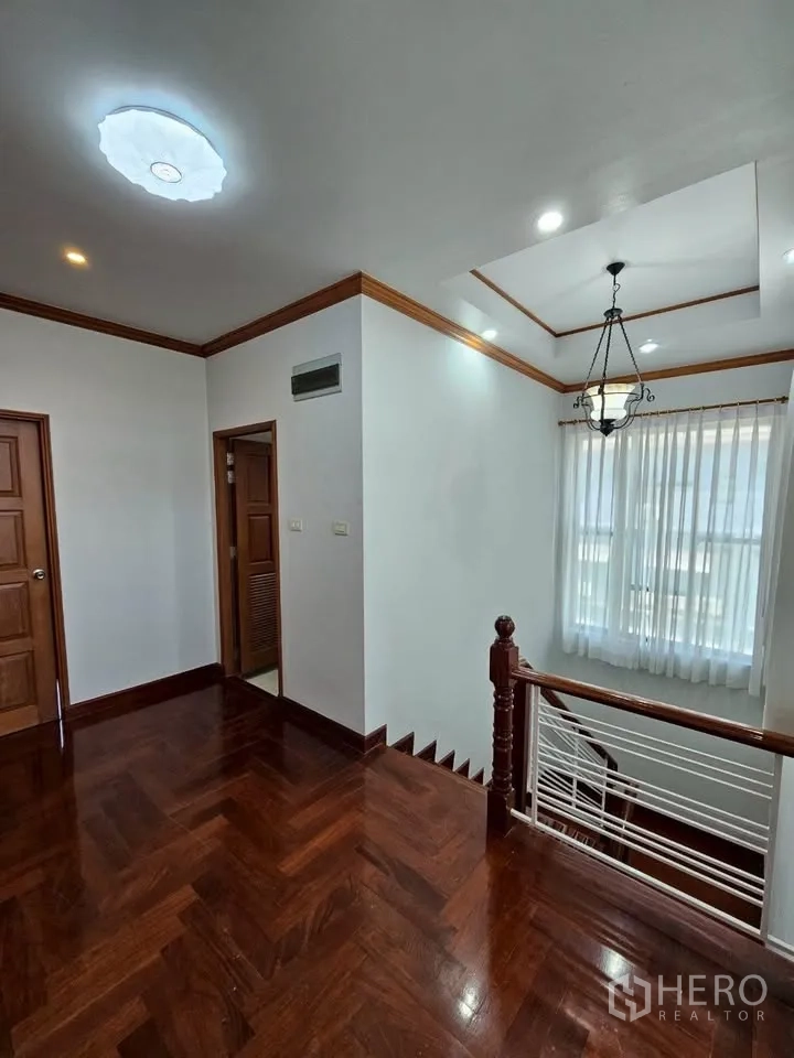 Home Office for rent in Wang Thonglang, Bangkok - Upper landing with wooden staircase, tray ceiling and sheer curtains bringing light.