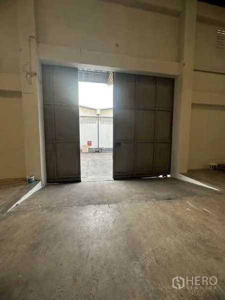 Warehouse for rent in Suan Luang, Bangkok - Tall steel sliding door opening to the warehouse loading area.