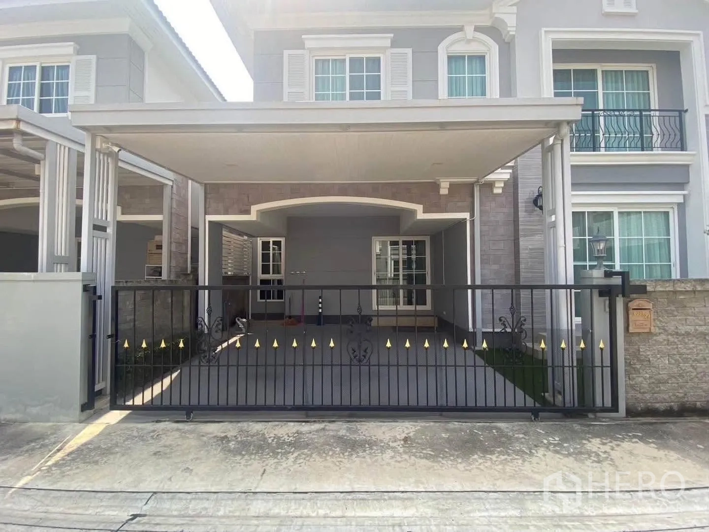 独栋房屋 for rent in Mueang Samut Prakan, Samut Prakan - 两层住宅外立面，带有顶棚车位与铁艺大门。