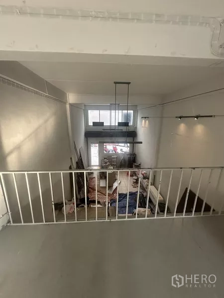 Shophouse for rent in Khlong Toei, Bangkok - Mezzanine view overlooking double-height shopfront under refurbishment.