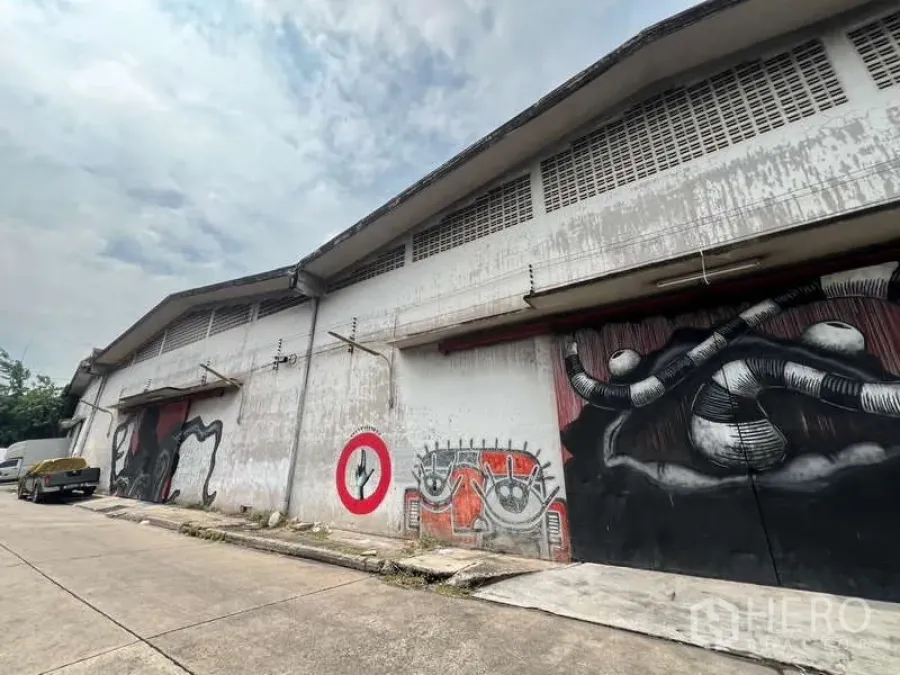 Warehouse for rent in Khlong Toei, Bangkok - Warehouse exterior with wide roller doors, loading bays, and street‑front facade featuring mural art.