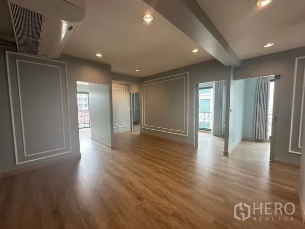 Home Office for rent in Suan Luang, Bangkok - Open-plan office floor with wood laminate, recessed lights, and grey paneled walls.