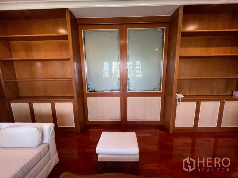 Detached House for rent in Bang Phli, Samut Prakan - Upstairs lounge or study featuring built-in wood bookshelves and glass doors.