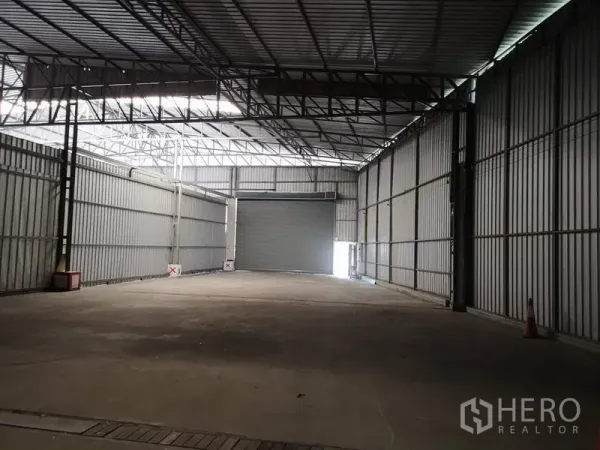 Warehouse for rent in Pak Kret, Nonthaburi - Loading bay area with an interior roller shutter door inside a metal‑clad warehouse.