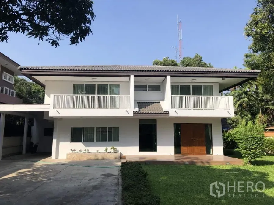 独立式住宅 出租在Suan Luang, Bangkok - 两层白色独栋别墅，双阳台，前院草坪与车道