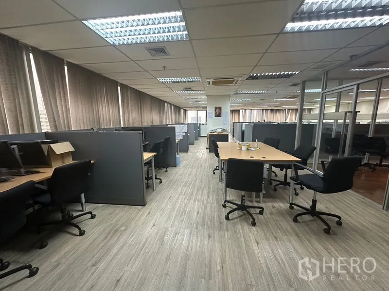 Office Space for rent - Open workspace with desks, chairs and cubicles under bright lighting