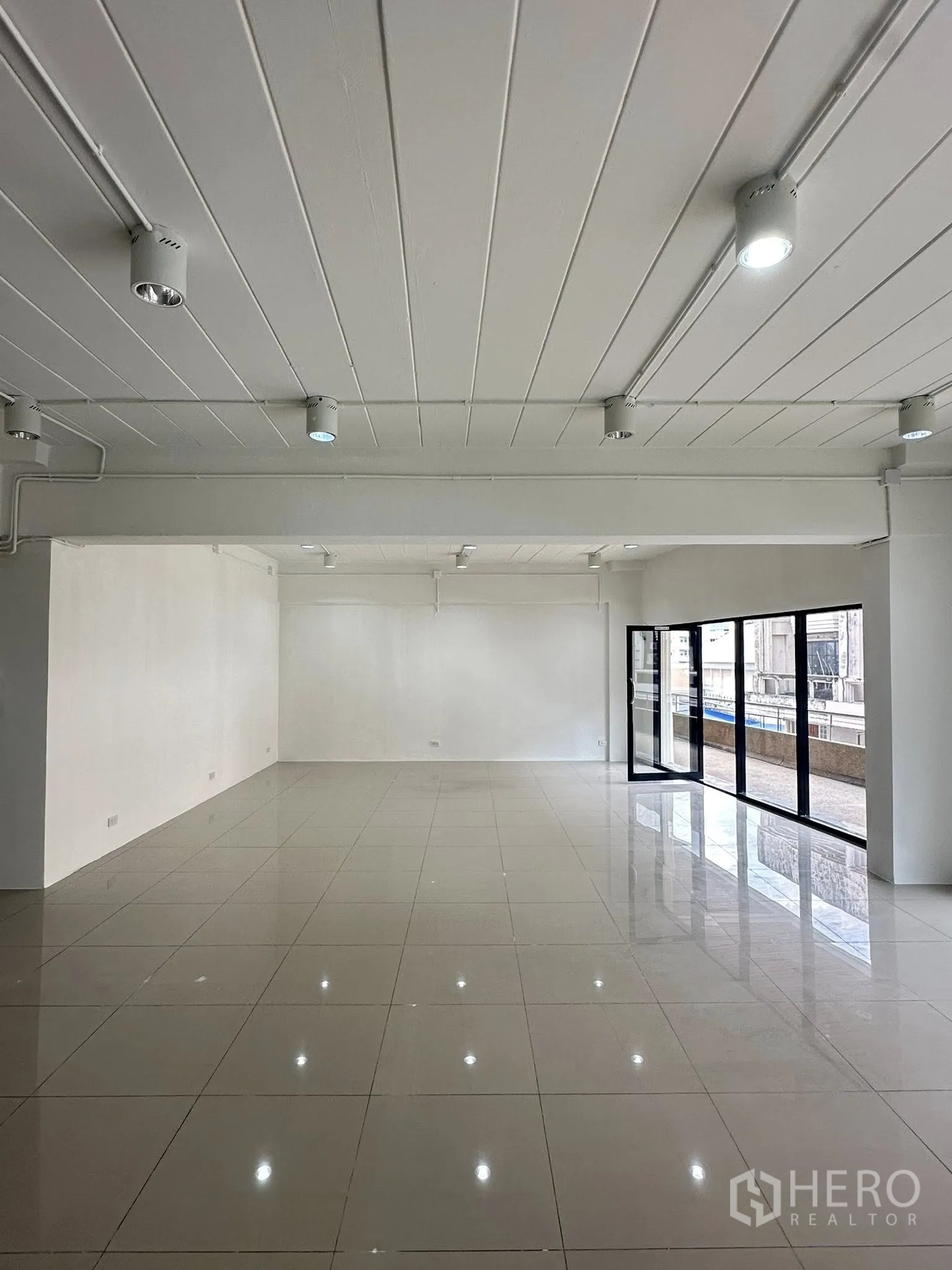 Office Space for rent in Watthana, Bangkok - Bright office space with floor-to-ceiling glass doors opening to a balcony walkway.