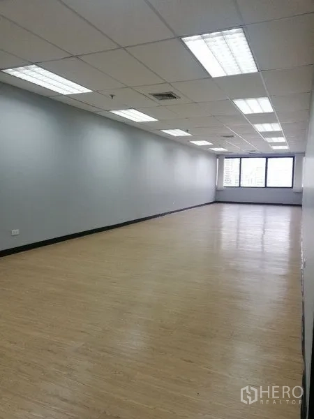 Office Space for rent in Watthana, Bangkok - Long open-plan office with drop ceiling, LED lights, and natural light from windows.