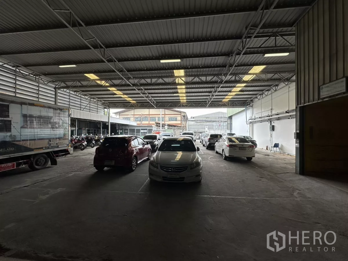 Warehouse for rent in Yan Nawa, Bangkok - Spacious covered drive‑through zone with vehicles and a delivery truck inside the warehouse.