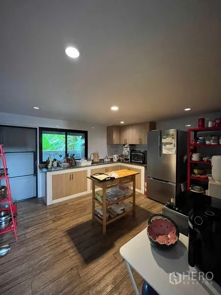 Home Office for rent in Bang Rak, Bangkok - Modern kitchen with island, wood-look flooring, window light and ample counter space.
