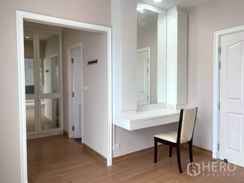 Detached House for rent in Suan Luang, Bangkok - Dressing corner with wall-mounted vanity, large mirror and hallway access.