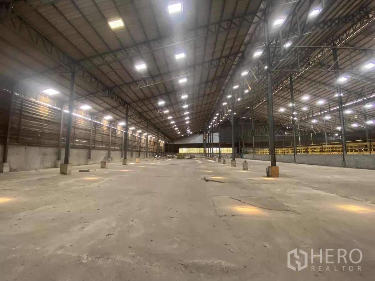 Factory for rent in Mueang Nakhon Pathom, Nakhon Pathom - Long central aisle of the warehouse showing skylights and expansive floor area.
