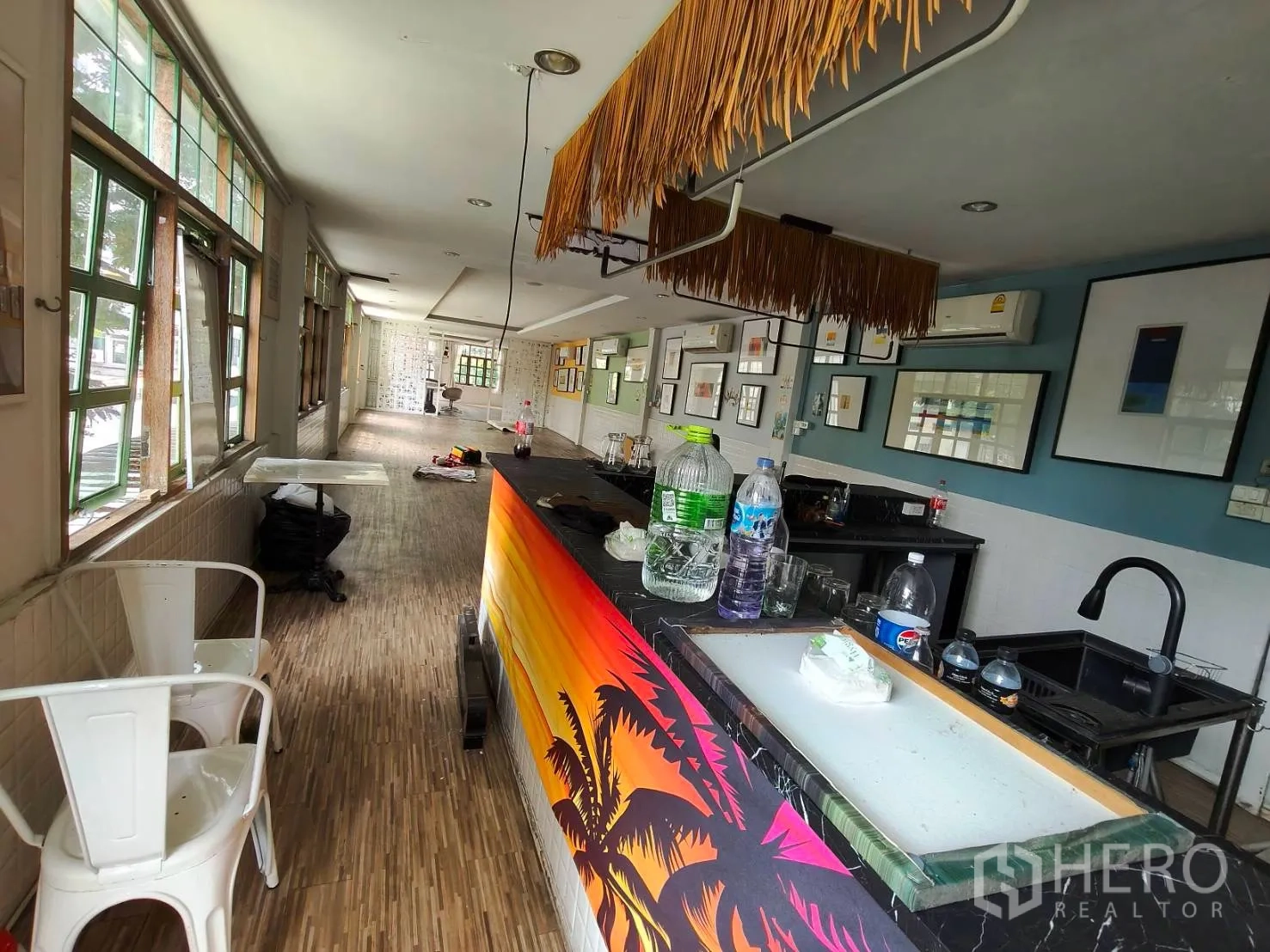 พื้นที่ขายของ for rent in Sathon, Bangkok - ภายในร้านกว้างพร้อมเคาน์เตอร์บาร์สีสันสด พื้นลายไม้ งานแขวนผนัง และหน้าต่างบานใหญ่