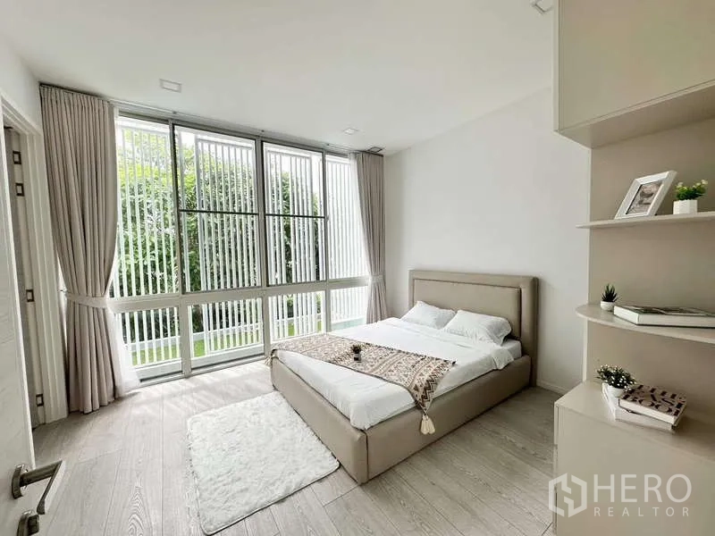 Detached House for rent or sale in Bang Phli, Samut Prakan - Guest bedroom with wide windows, built-in shelves and a garden view.