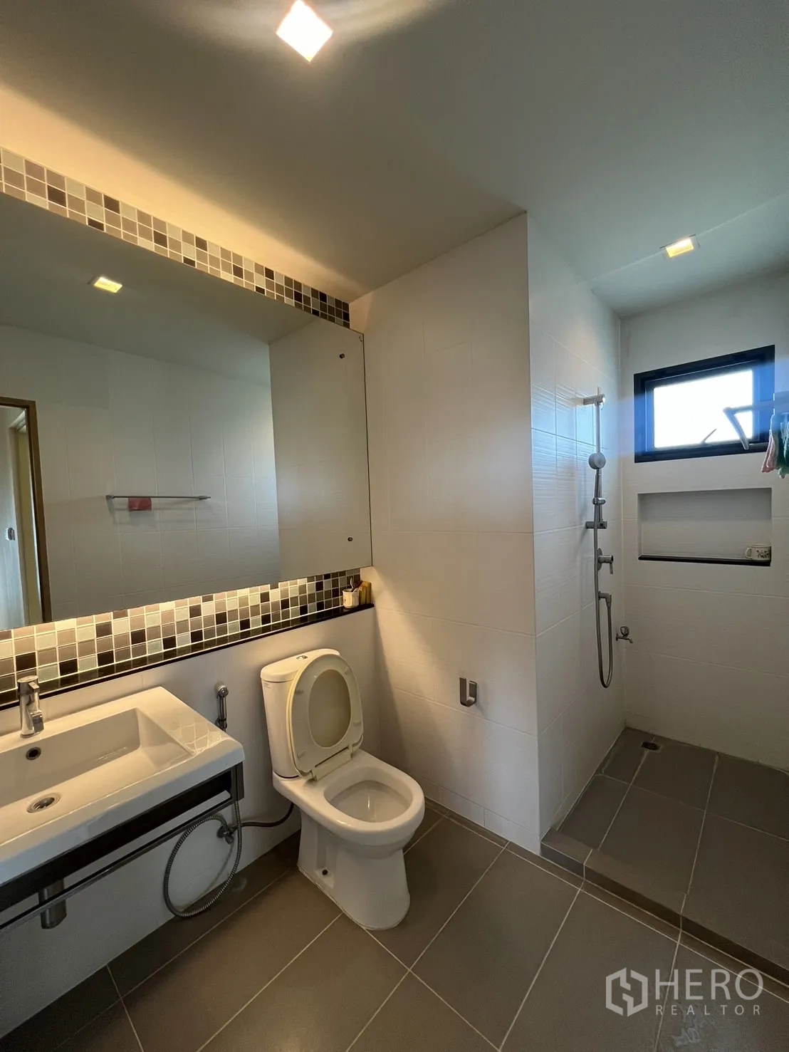 Detached House for rent in Bang Kapi, Bangkok - Upper bathroom with large mirror, mosaic tiles, and separate shower zone.