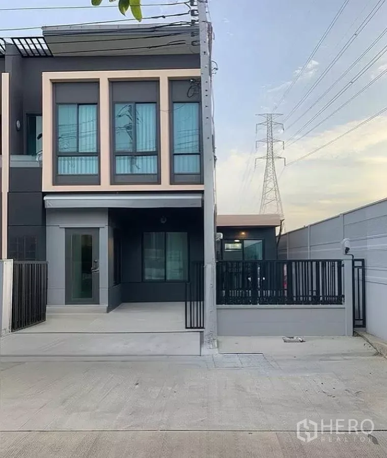 Townhouse for rent in Bang Phli, Samut Prakan - Modern two-storey townhouse facade with gated parking and wide driveway in Bang Phli.