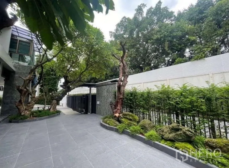 Detached House for sale in Khlong Toei, Bangkok - Driveway entrance with hedges, rock garden and metal gate.