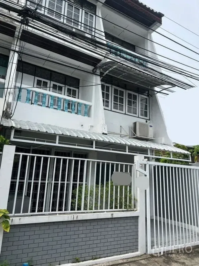 Townhouse for rent in Khlong Toei, Bangkok - Three-storey white townhouse with gated front yard near BTS Ekkamai.
