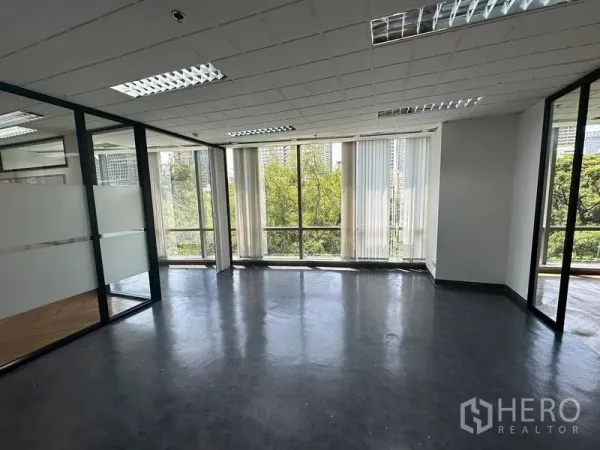Office Space for rent - Corner office with full-height windows, city and tree views, and dark vinyl flooring.