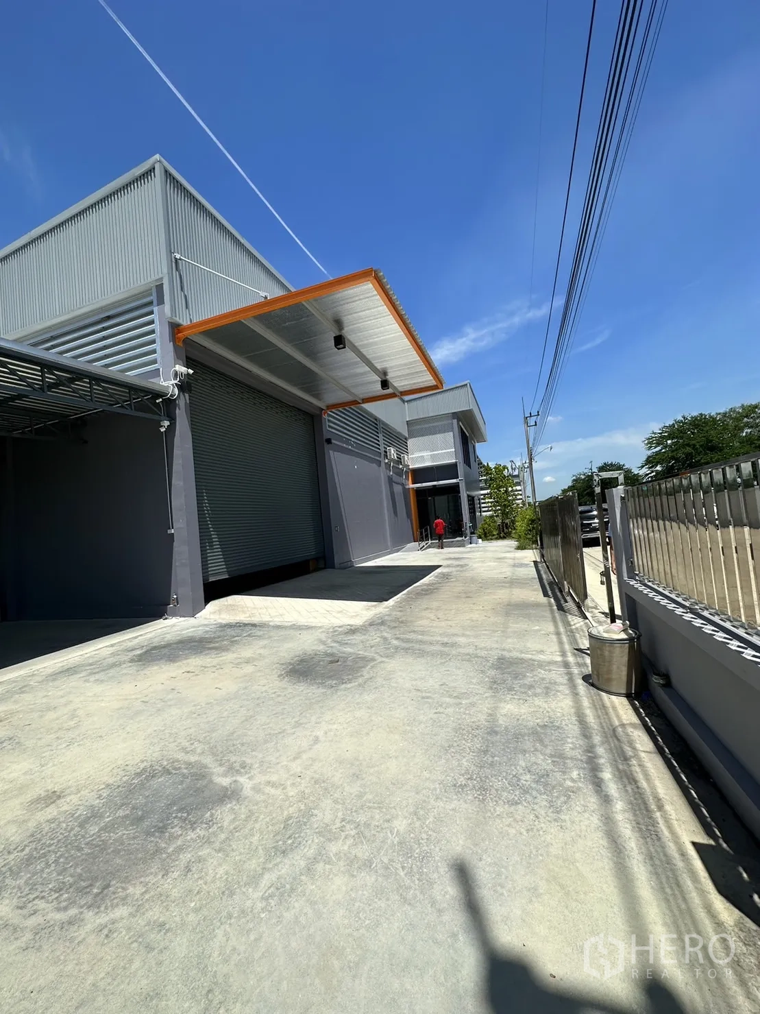Factory for sale in Lam Luk Ka, Pathum Thani - Front elevation with roller shutters and wide concrete apron.