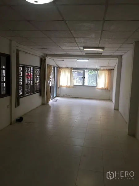 联排别墅 出租在Khlong Toei, Bangkok - 宽敞前厅起居区，大窗户与米色窗帘