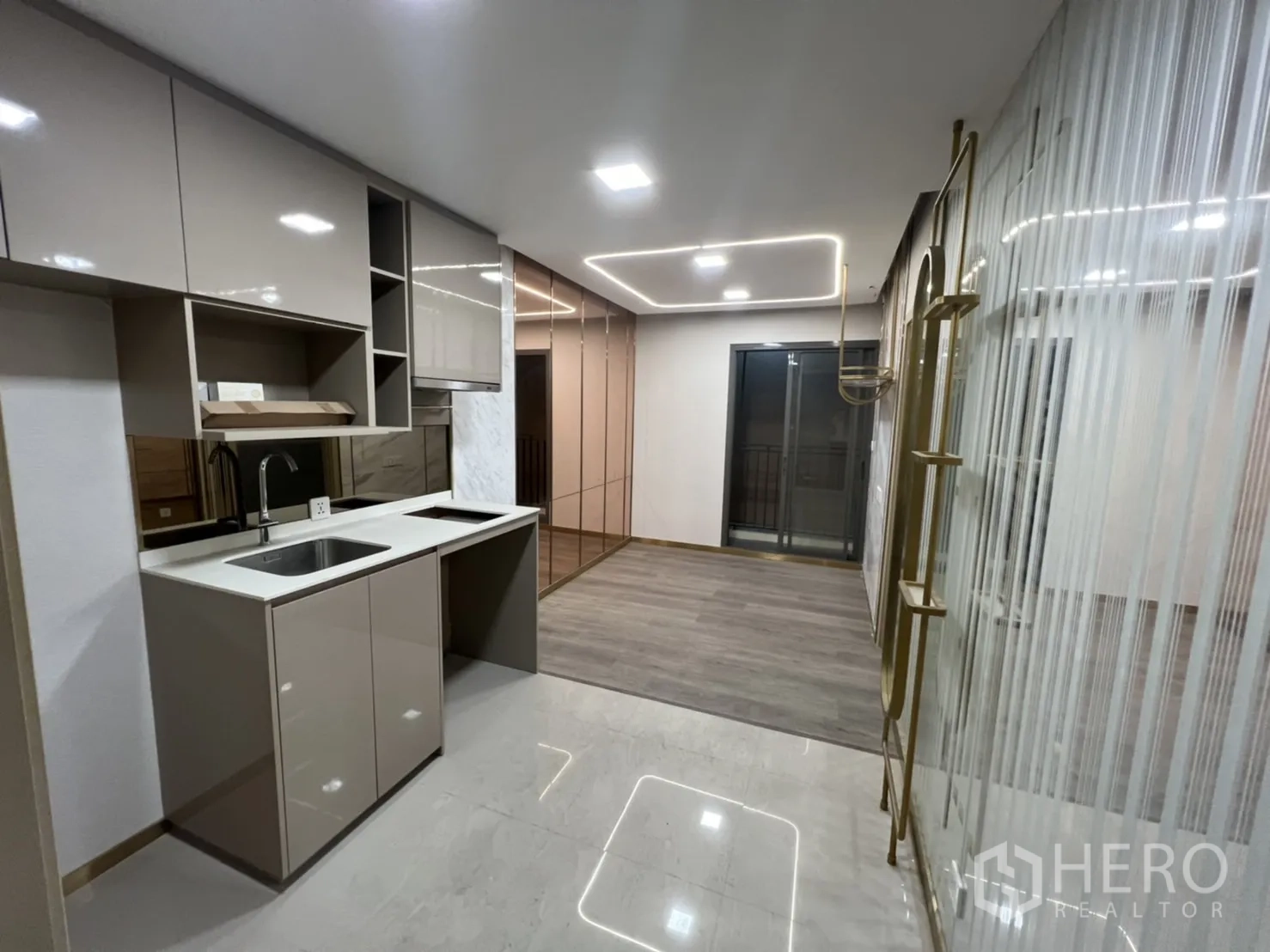 Shophouse for rent in Phra Khanong, Bangkok - Pantry with built‑in cabinets, sink and adjacent open workspace.