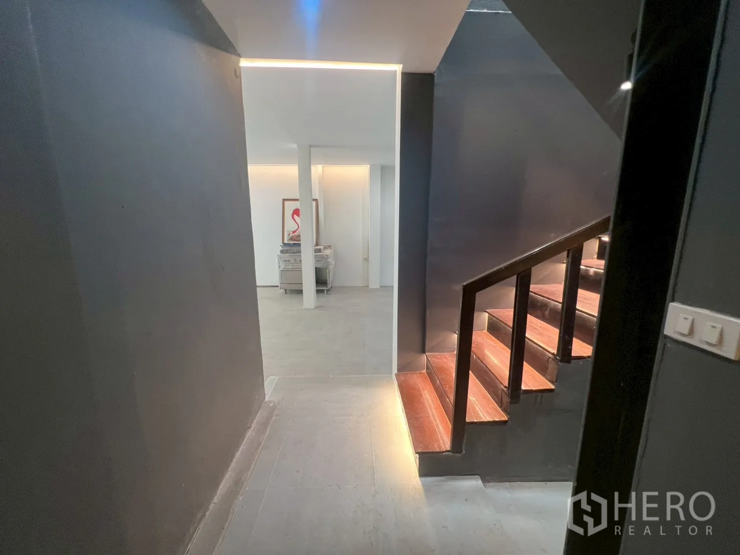 โฮมออฟฟิศ for rent in Watthana, Bangkok - โถงทางเดินผนังสีเข้มและบันไดไม้มีไฟบันได