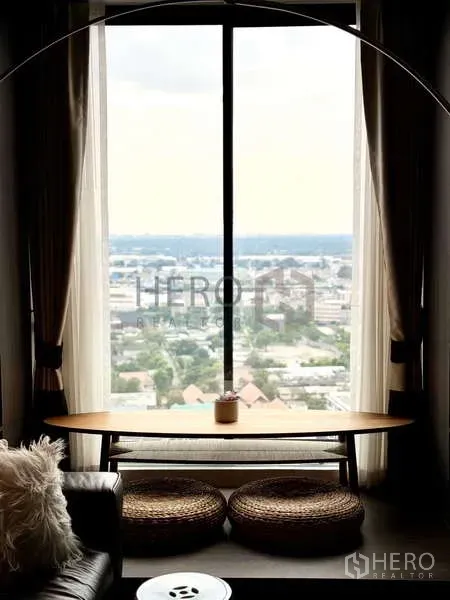 Condominium for rent - Zen balcony nook with bench table, woven cushions and a wide Bangkok city view.
