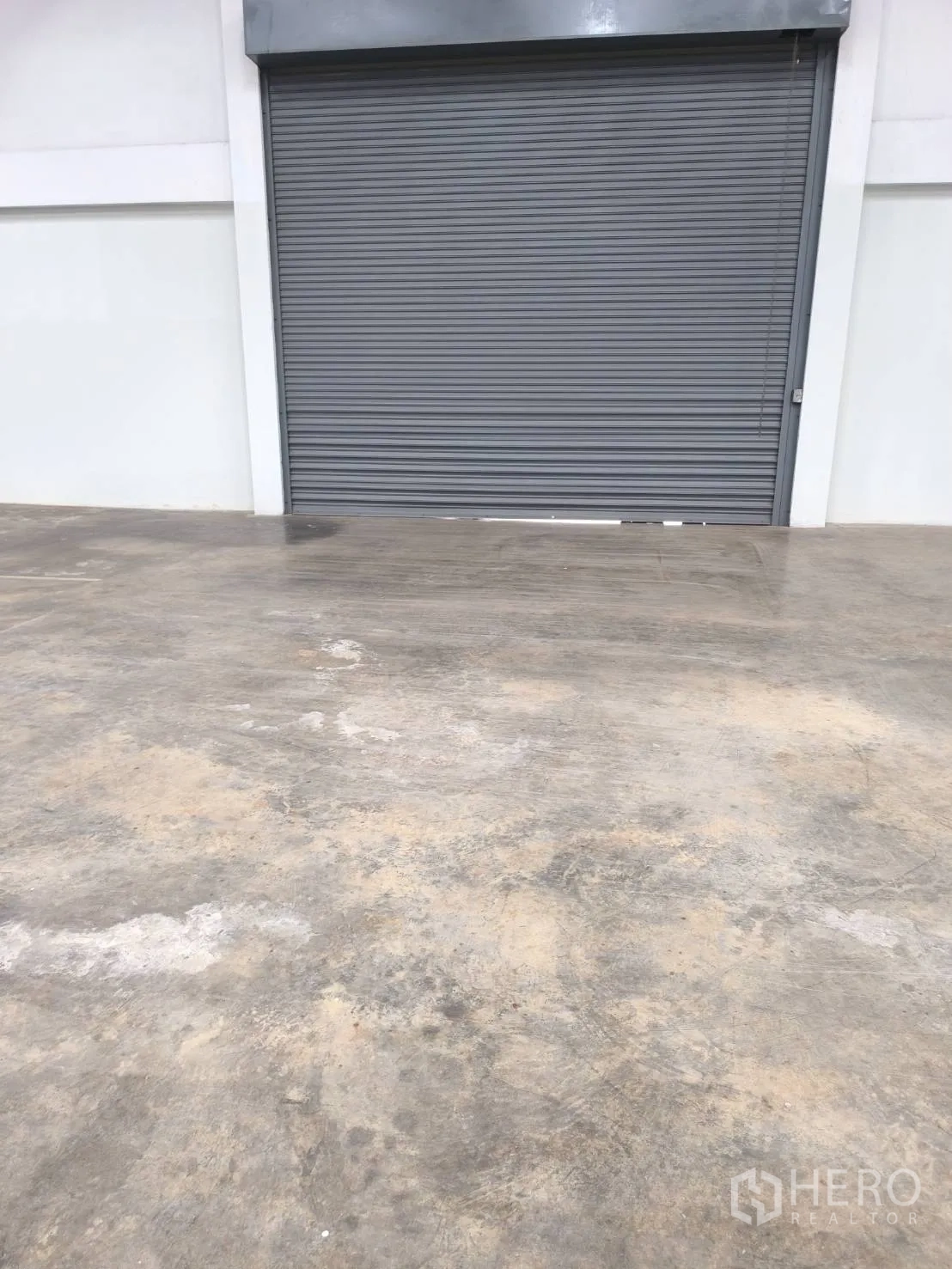 工厂 for sale in Khlong Luang, Pathum Thani - 仓库内灰色卷帘门近景。