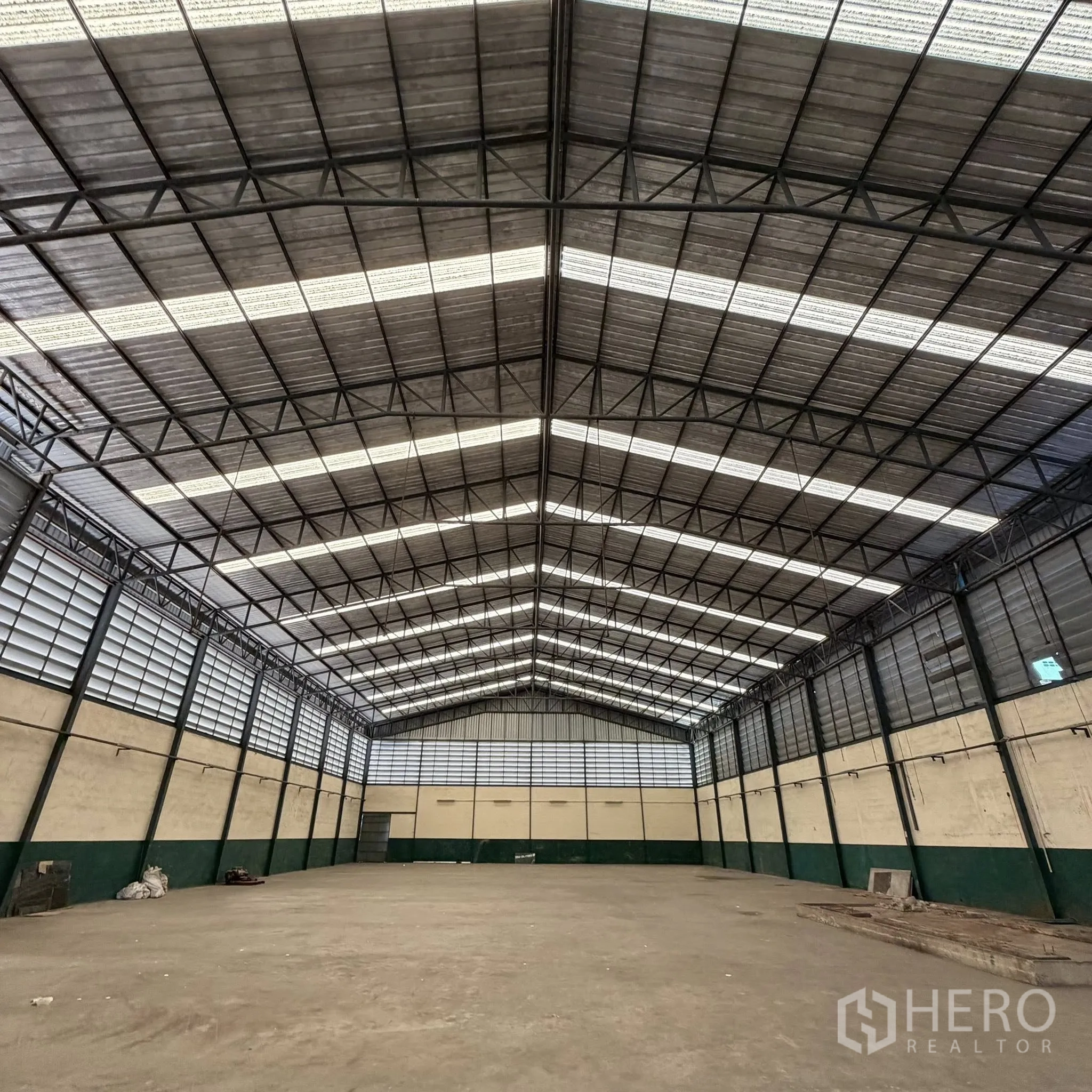 Factory for rent in Phra Pradaeng, Samut Prakan - Large clear-span warehouse with a high gabled roof and ventilated panels.