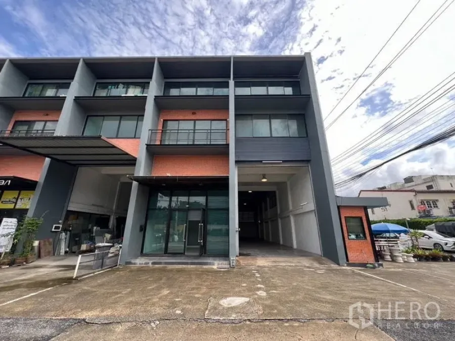 Warehouse for rent in Bang Phli, Samut Prakan - Exterior view of the same three-storey warehouse building with driveway parking.