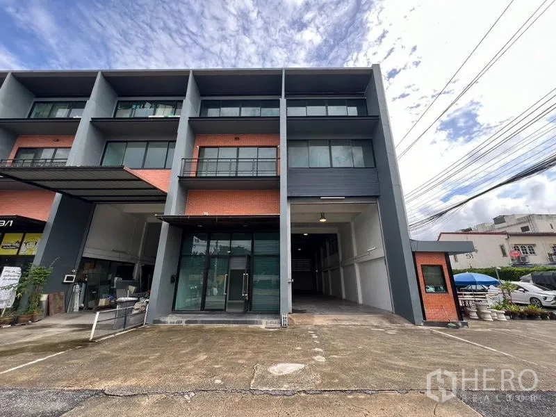 Warehouse for rent in Bang Phli, Samut Prakan - Exterior view of the same three-storey warehouse building with driveway parking.