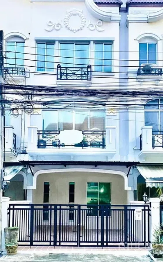 Townhouse for rent in Prawet, Bangkok - Three-storey white townhouse exterior with gated parking and balconies on Srinakarin.