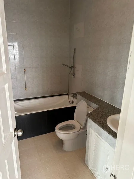 Townhouse for rent in Bang Kapi, Bangkok - Bathroom with bathtub, toilet and long vanity counter.