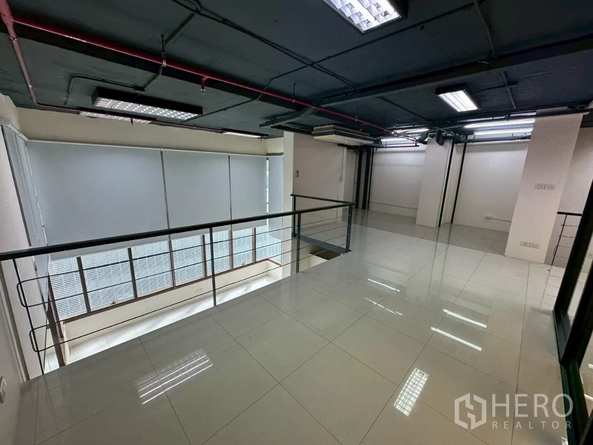 Office Space for rent in Khlong Toei, Bangkok - Wide mezzanine workspace with fluorescent lighting and tiled floor.