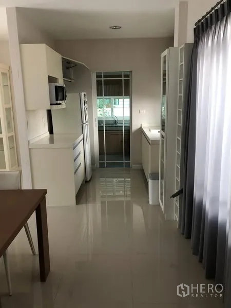 Detached House for rent in Bang Kapi, Bangkok - Pantry corridor leading to a separate kitchen with glass door and natural light.
