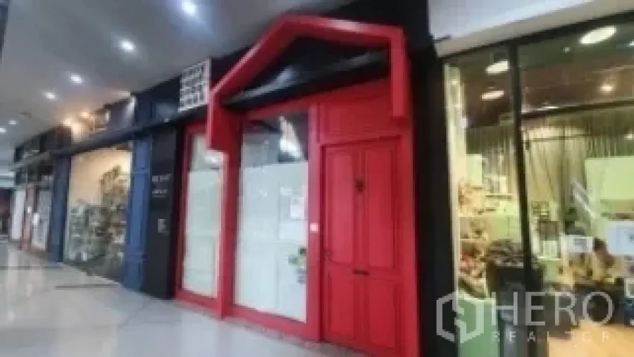 Retail Space for rent in Khlong Toei, Bangkok - Storefront with red facade along an indoor shopping arcade walkway.