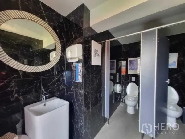 Retail Space for rent in Bang Rak, Bangkok - Modern restroom with black marble walls, sink and private toilet stalls.