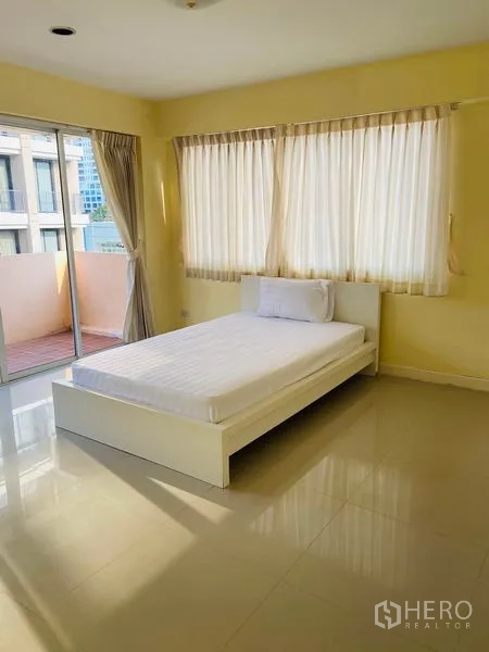 Detached House for rent in Watthana, Bangkok - Bedroom with single bed, large windows and sliding door to a private balcony.