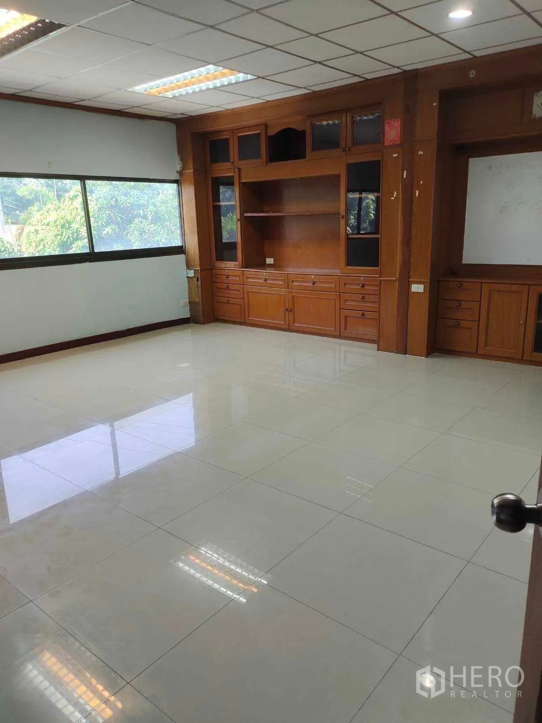 Factory for sale in Nikhom Phatthana, Rayong - Private office fitted with built-in wooden cabinetry and a large window.