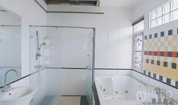Detached House for sale in Bang Kapi, Bangkok - Bright bathroom with glass shower, jetted bathtub, tiled walls and a window.