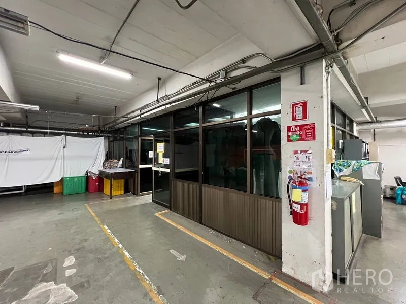 货栈 出租在Bang Kapi, Bangkok - 室内角落带玻璃隔断办公室，可见线路与灭火器，工业环境完善。