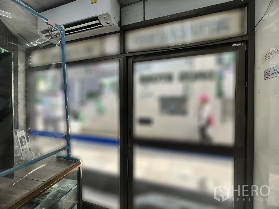 อาคารพาณิชย์ ขายในWatthana, Bangkok - มุมมองจากภายในบริเวณทางเข้า ประตูกระจกกรอบอลูมิเนียมและเครื่องปรับอากาศติดผนัง
