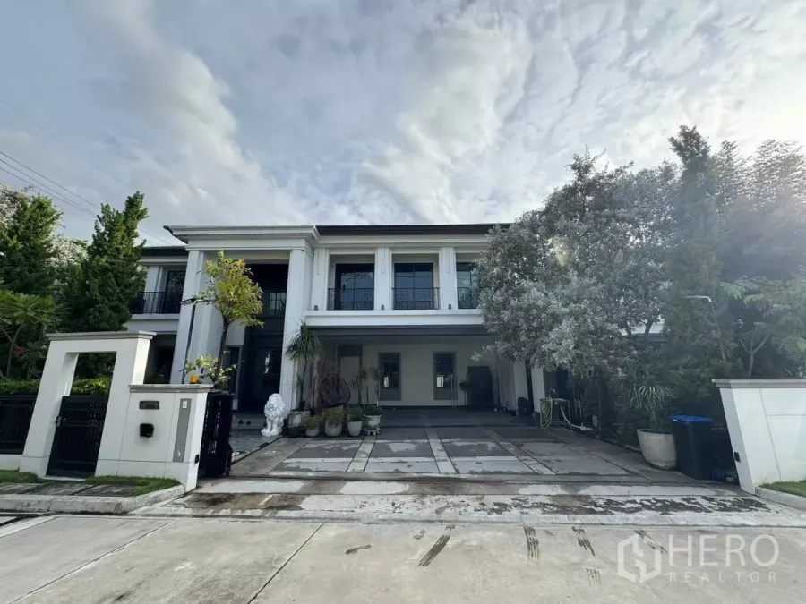 Detached House for sale in Mueang Pathum Thani, Pathum Thani - Two-storey luxury detached house facade with double-height columns, gated driveway and landscaped trees.