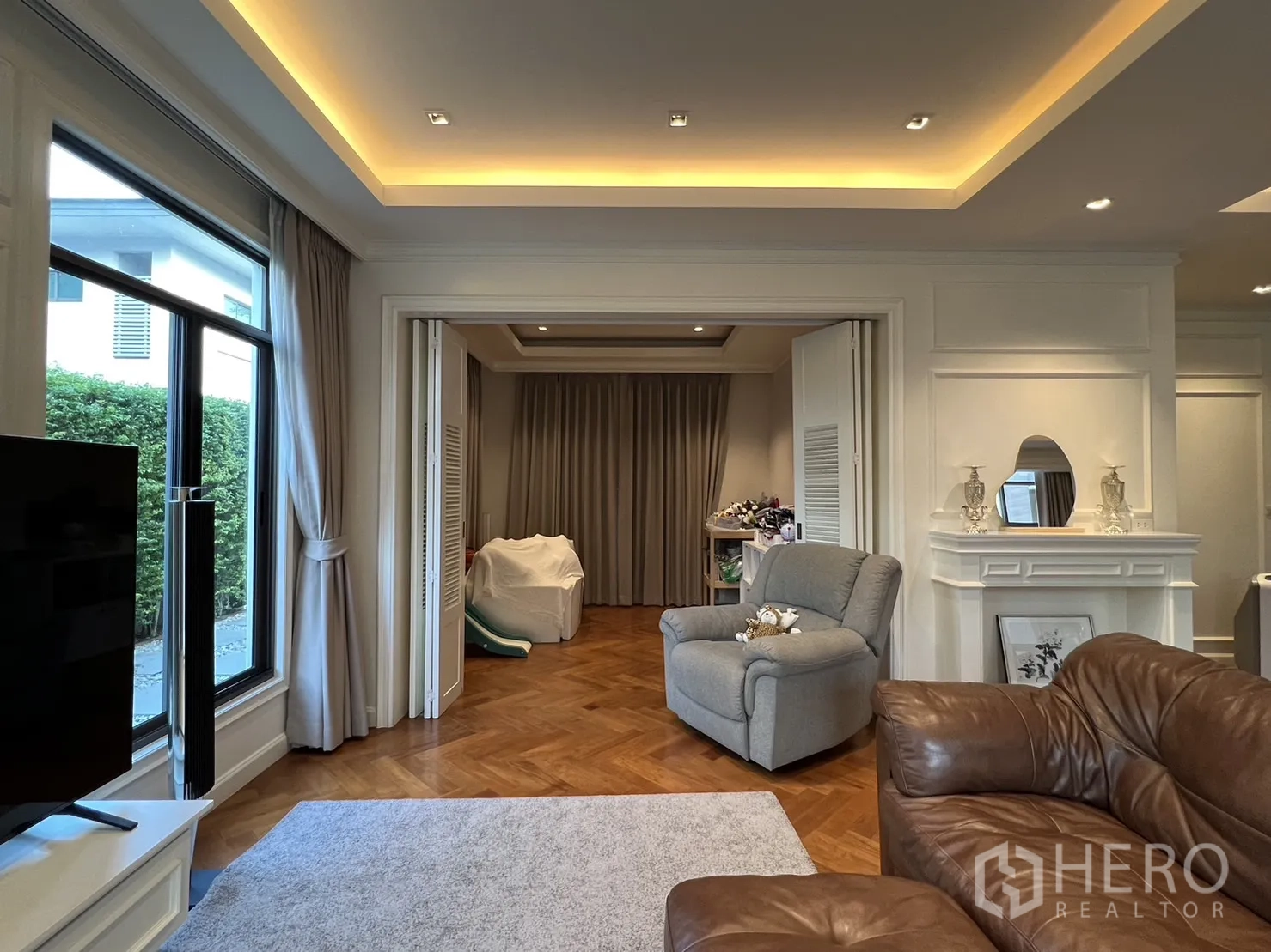 独立式住宅 出租在Suan Luang, Bangkok - 客厅带折叠门，通向多功能房。