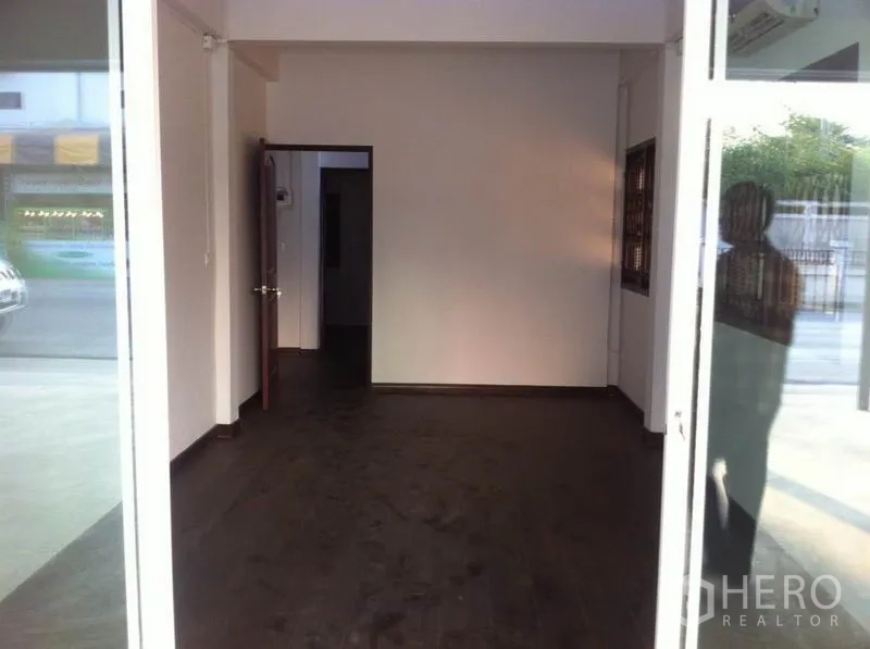 货栈 出租在Lam Luk Ka, Pathum Thani - 一层办公室/展示区，玻璃入口与深色木地板。